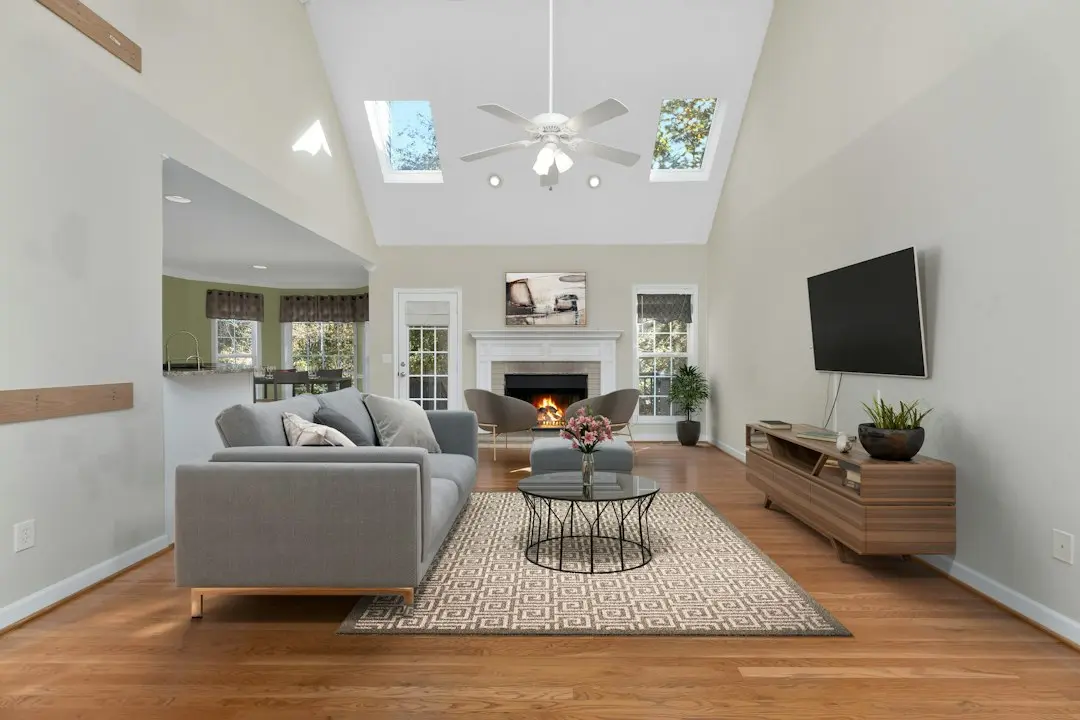 A bright family room with a gray sofa facing a wall-mounted TV, set up for MeezzyTV IPTV in the USA