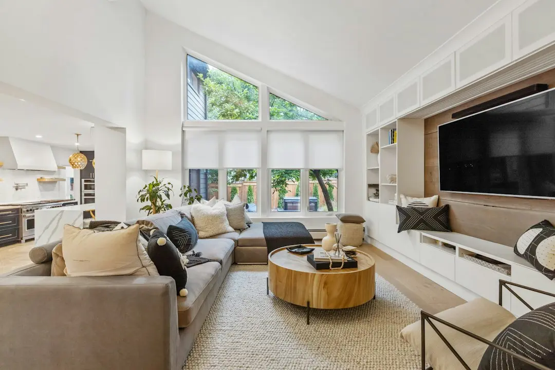 A bright living room with a large wall-mounted TV and a sofa, ready to stream MeezzyTV from a Fire TV Stick
